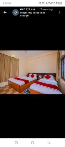 two beds in a room with red and white sheets at Hotel Bien Venue in Pokhara