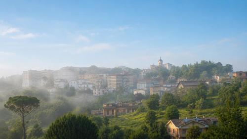 a small town on a hill in the fog at Souvenir D Italie in Alatri