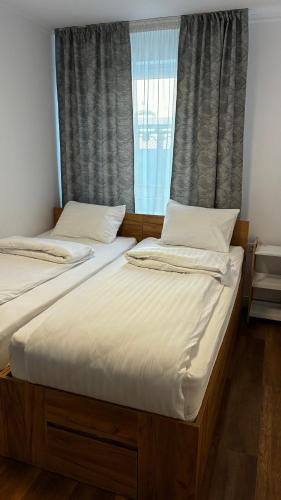 two twin beds in a room with a window at Garden vibe apartament in Luduş