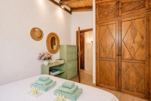 a bedroom with a bed with two towels on it at Caprifogli Townhouse Close to the Beach in Baja Sardinia