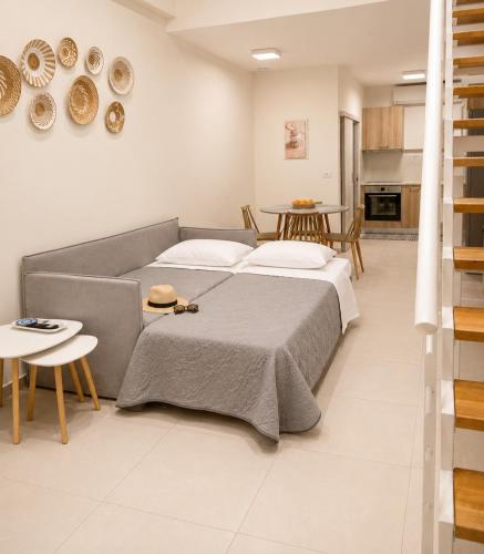 two beds in a room with a couch and a table at Thalassa loft in Tolo in Tolo