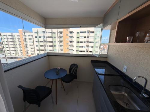 a balcony with a table and chairs and a sink at Condomínio Club Resort 2 quartos com ar na melhor da Aruana in Aracaju