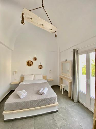a bedroom with a bed with two pillows on it at Villa Markos in Perissa