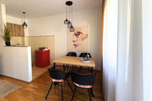 a small kitchen with a wooden table and chairs at Boho Apartments in Trebinje