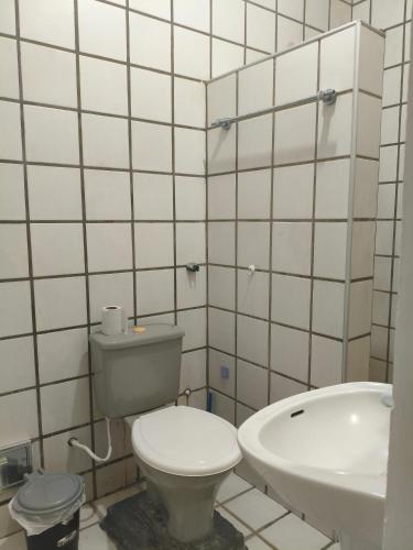 a white bathroom with a toilet and a sink at Pousada Bom Jesuss in Juazeiro do Norte