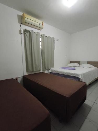 a room with two beds and a window in it at Pousada Bom Jesuss in Juazeiro do Norte