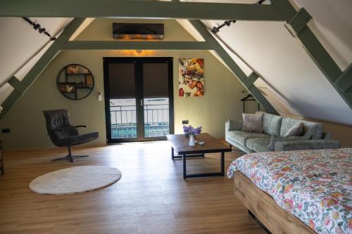 a bedroom with a bed and a couch and a table at DuinDroom bovenappartement, Beverwijk in Beverwijk