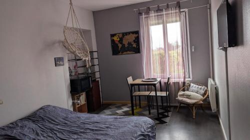 a bedroom with a bed and a table and chairs at Chambre studio in Sublaines