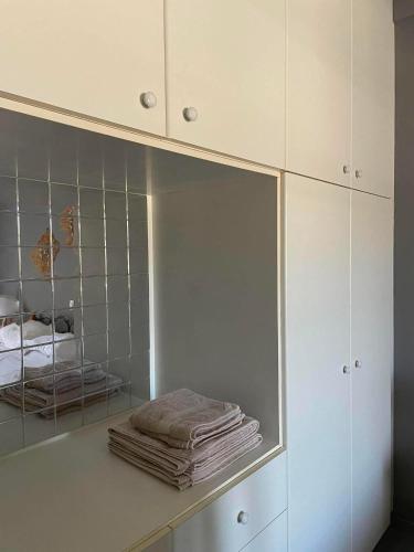 ein weißer Schrank mit Spiegel und einigen Handtüchern in der Unterkunft Stivari view in Batsi