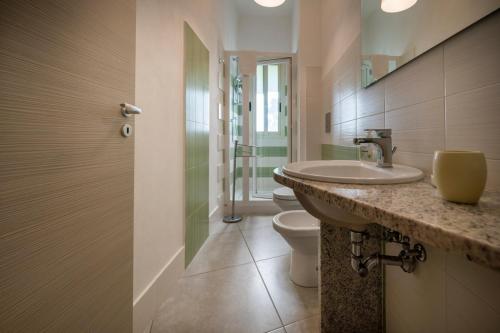 a bathroom with a sink and a toilet at Villa Fontane Bianche in Fontane Bianche