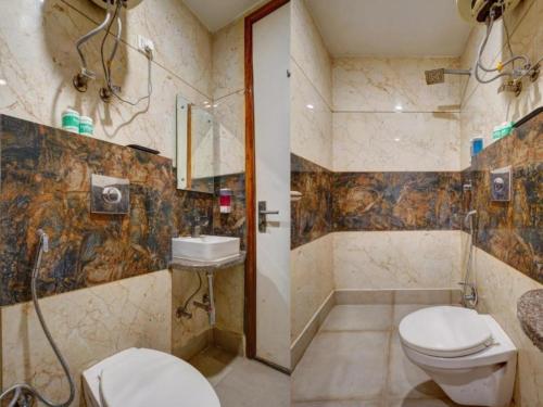 a bathroom with a toilet and a shower and a sink at Hotel Urban ECG Grand - Inn Near IGI Delhi Airport in New Delhi