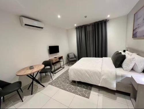 a hotel room with a bed and a desk and a computer at Green Palm Resort Lekki in Ikuata