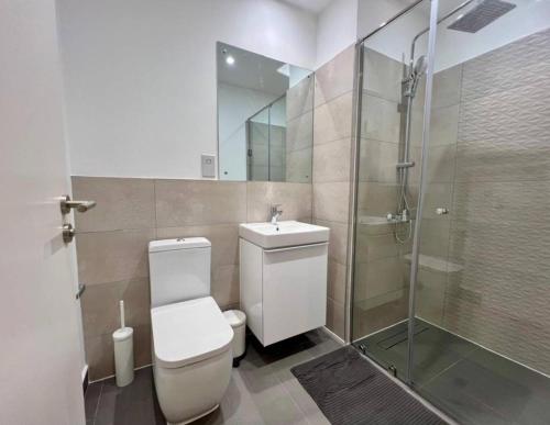 a bathroom with a toilet and a glass shower at Green Palm Resort Lekki in Ikuata