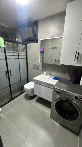 a bathroom with a sink and a washing machine at Lefkali HOME in Çınarlık