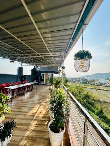 a balcony with tables and potted plants on it at Hotel Mount View in Haldwāni