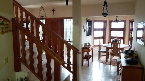 a living room with a staircase and a dining room at Refúgio do Azzi in Monte Verde