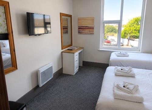 a hotel room with two beds and a tv at The Saltley Inn in Birmingham