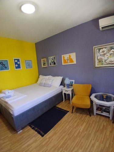 ein Schlafzimmer mit einem großen Bett und einem Stuhl in der Unterkunft Sun Garden in Čitluk