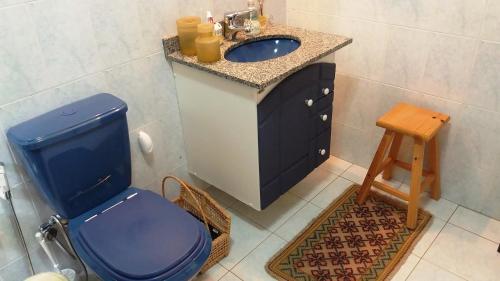 a bathroom with a blue toilet and a sink at Refúgio do Azzi in Monte Verde