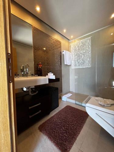 a bathroom with a sink and a shower and a tub at VILLA KTIMA MELINA Pelio ΒΙΛΑ ΜΕ ΠΙΣΙΝΑ ΒΟΛΟΣ ΠΗΛΙΟ in Álli Meriá