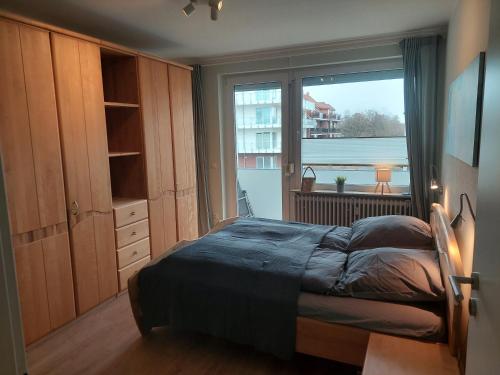 a bedroom with a bed and a large window at NordseeGlück in Cuxhaven