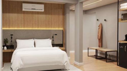 a bedroom with a white bed and a closet at Hotel Campo Largo Comfort in Campo Largo
