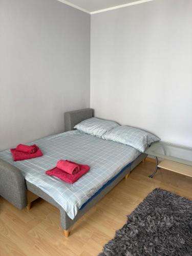 a bed with two red towels on it in a room at Daniel Apartment in Reda