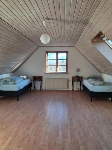 a room with two beds and a wooden ceiling at Bakkely in Rønnede