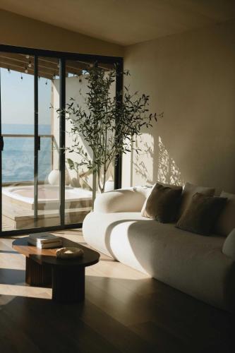 a living room with two beds and a table at Kasa Dharma an oceanfront House in El Suazal