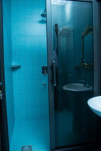 a bathroom with a glass shower door next to a sink at Monga's Apartments in Ndola