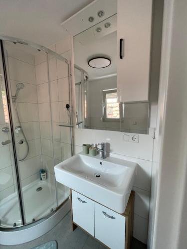 a white bathroom with a sink and a shower at Gemütliche Wohnung mit WLAN, TV und Parkplatz in Groß-Umstadt