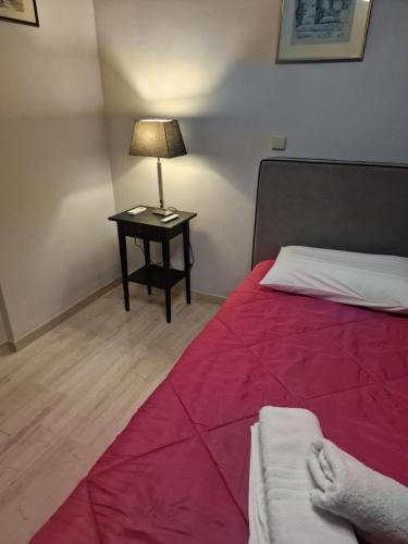 a bedroom with a bed and a table with a lamp at Nicolas luxury apartment in Amalias