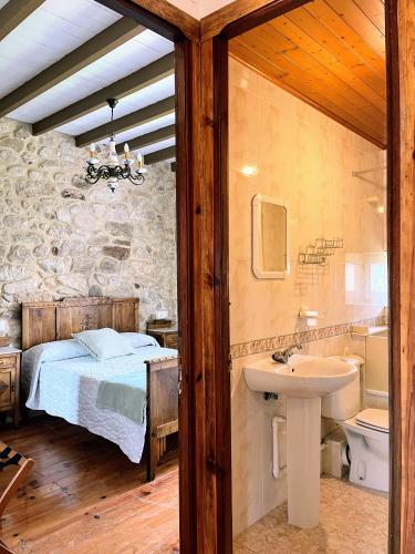 a bedroom with a bed and a sink and a bathroom at Casa Rua in Lira
