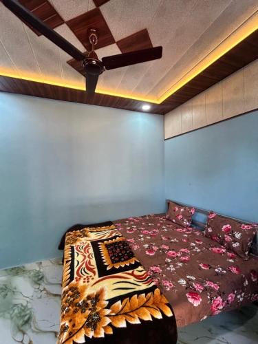a bedroom with a bed with a ceiling fan at Serenity House in Matheran