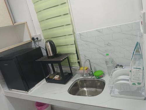 a kitchen counter with a sink and a microwave at Tiny House Anjung Batu Tangkak in Tangkak