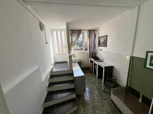 a room with a staircase with a window and a desk at Budva Apartment with Private Parking in Budva