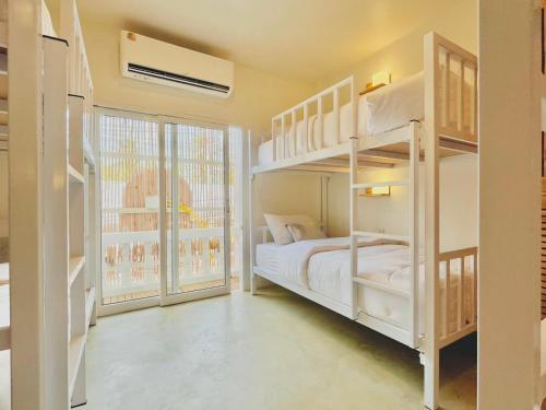 a bedroom with two bunk beds and a window at Hi Sea Hostel - Boutique Style in Center, 15 min Walk from Pier in Thong Sala