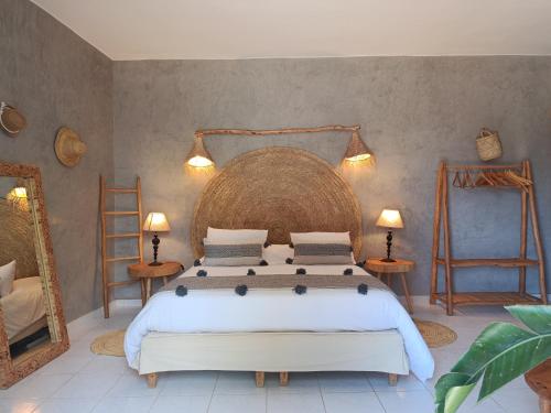 a bedroom with a large bed and two mirrors at Villa Daba By Zelia in Ghazoua
