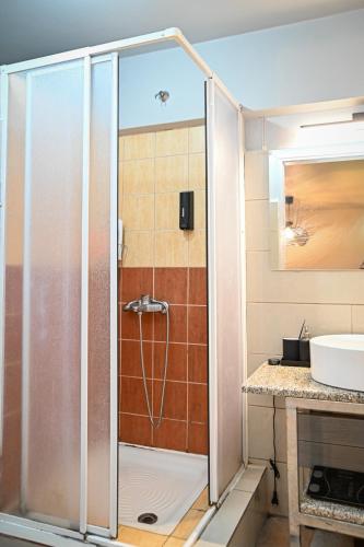 a shower in a bathroom with a sink at West of Preveza Luxury Jacuzzi Apartment in Preveza