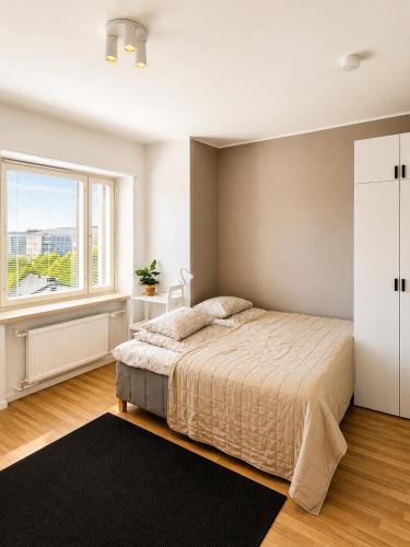 a bedroom with a bed and a large window at Gallen-Kallelankatu 9 in Pori