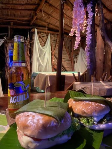 a table with two sandwiches and a bottle of beer at Bio Hotel - Eco Glamping El Refugio in Gigante