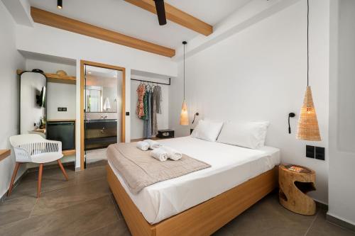 ein Schlafzimmer mit einem großen Bett und einem Stuhl in der Unterkunft Fragiskos Hotel in Matala