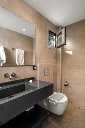 ein Badezimmer mit schwarzem Waschbecken und Toilette in der Unterkunft Fragiskos Hotel in Matala