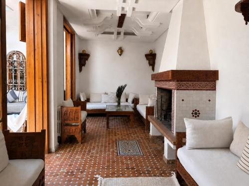 a living room with a fireplace and a couch at Bright Riad with Panoramic Views - Oudayas in Rabat