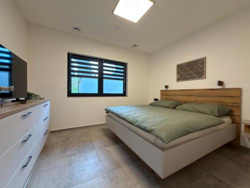 a bedroom with a large bed and a kitchen at Black Diamond Apartments in Kobylnice