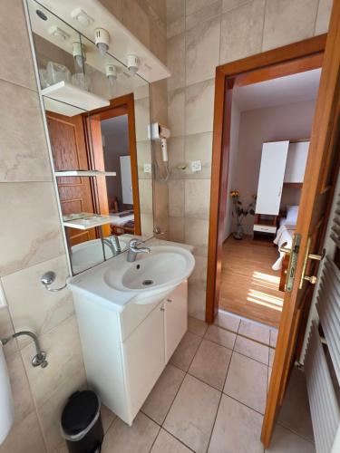 a bathroom with a white sink and a mirror at Villa Palčić in Novalja
