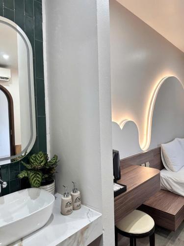 a bathroom with a sink and a mirror and a bed at Hidden Green Hotel Tam Coc in Vũ Lâm