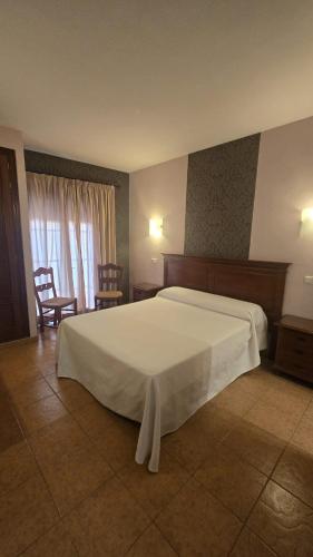 a bedroom with a large white bed and two chairs at Don Alfredo in Marbella