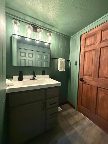 a bathroom with a sink and a mirror and a door at The Remington House in Woodruff