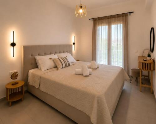a bedroom with a large bed with two towels on it at Pagonia Apartments in Arillas